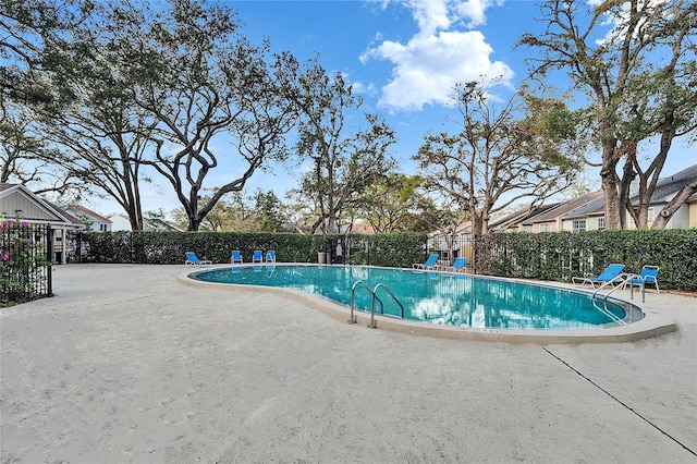 community pool featuring fence and a patio