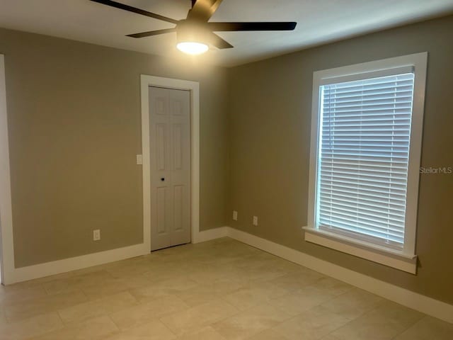 empty room with baseboards and ceiling fan