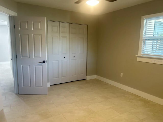 unfurnished bedroom featuring baseboards, a closet, and ceiling fan