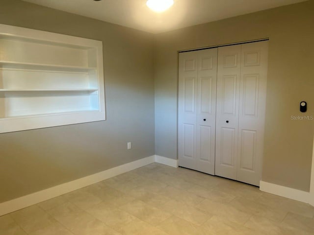 unfurnished bedroom featuring baseboards and a closet