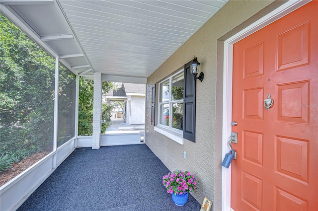 property entrance featuring a porch and stucco siding