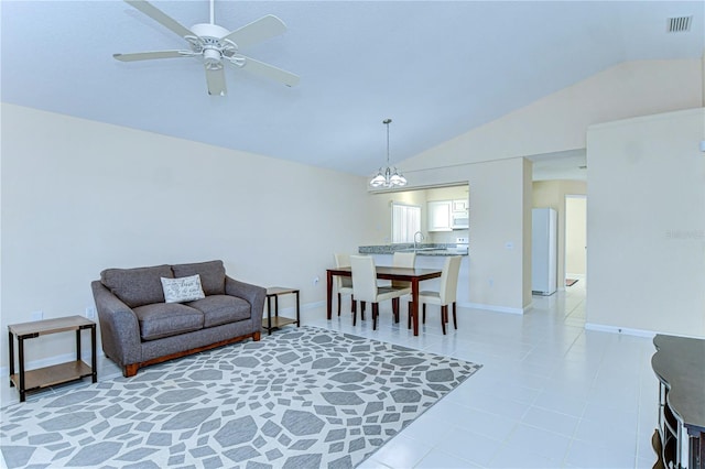 living area featuring light tile patterned floors, lofted ceiling, visible vents, baseboards, and ceiling fan with notable chandelier