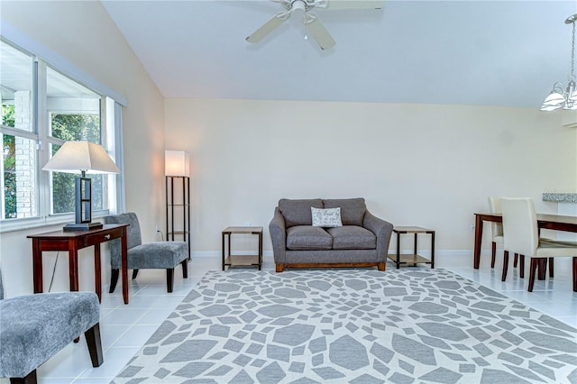 living room with ceiling fan with notable chandelier, baseboards, and light tile patterned floors