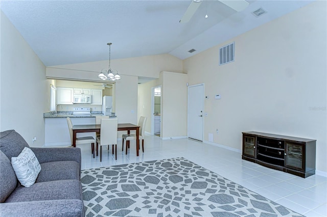 dining area with light tile patterned floors, lofted ceiling, visible vents, and baseboards