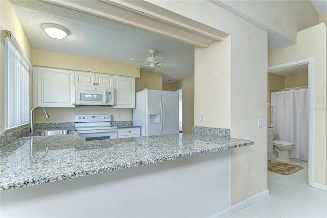 kitchen featuring ceiling fan, white appliances, a sink, white cabinetry, and light stone countertops