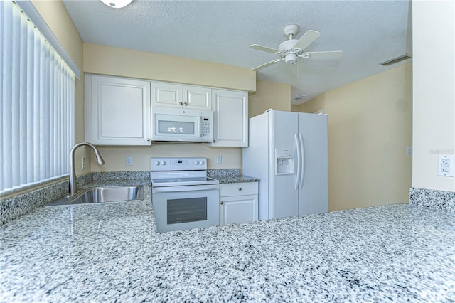 kitchen with visible vents, white cabinetry, a sink, a textured ceiling, and white appliances