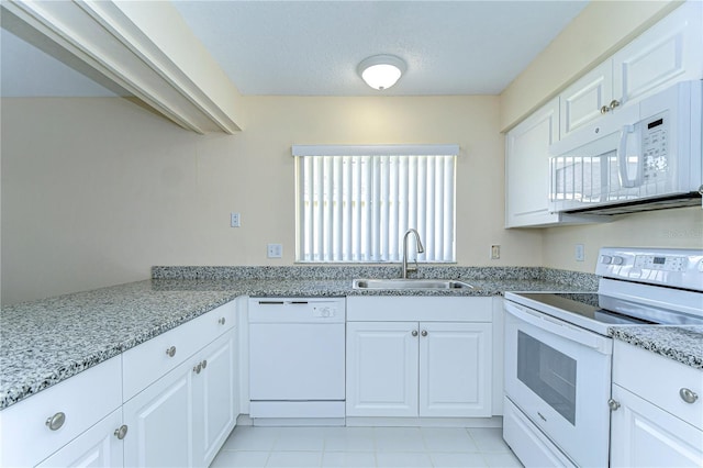 kitchen featuring light stone counters, white cabinetry, a sink, a textured ceiling, and white appliances