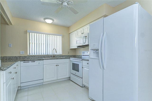 kitchen featuring light stone counters, a ceiling fan, white cabinets, a sink, and white appliances