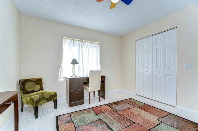 tiled home office with a textured ceiling, a ceiling fan, and baseboards