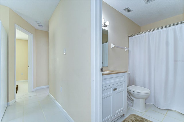 bathroom featuring baseboards, visible vents, toilet, tile patterned floors, and vanity