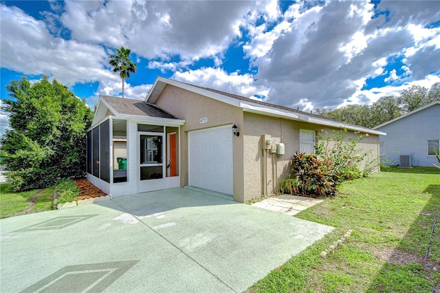 view of front facade featuring a garage, a sunroom, concrete driveway, stucco siding, and a front yard