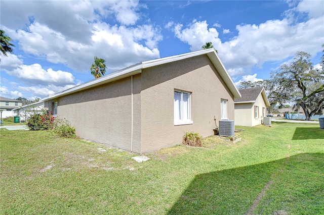 view of property exterior featuring a lawn, cooling unit, and stucco siding