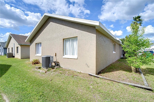 view of property exterior with central AC, a yard, and stucco siding