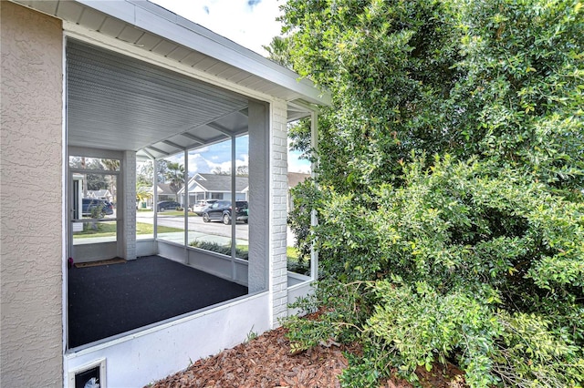 view of home's exterior featuring a sunroom, a carport, and stucco siding