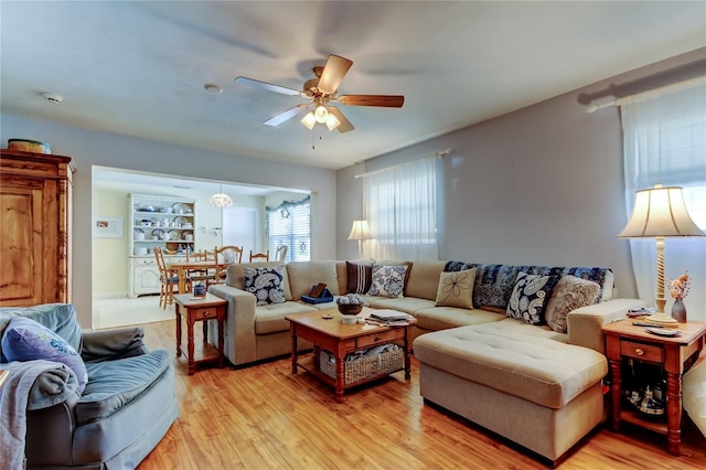 living area with ceiling fan and light wood-style flooring