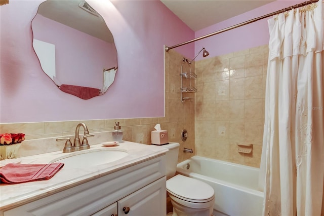 bathroom with toilet, shower / bath combo, tile walls, and vanity