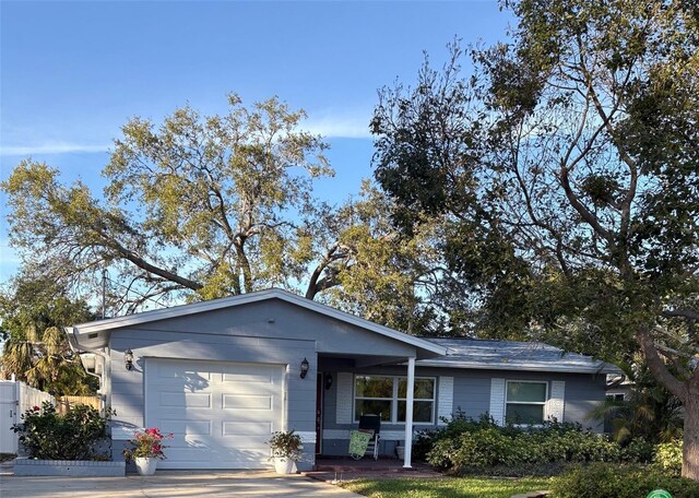 ranch-style house featuring a garage, driveway, and fence