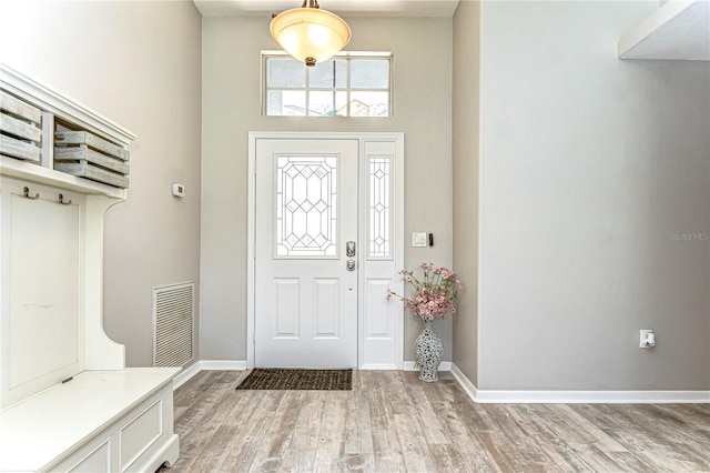 entryway with visible vents, light wood-style flooring, and baseboards