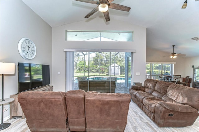 living room featuring visible vents, a sunroom, ceiling fan, light wood-type flooring, and high vaulted ceiling