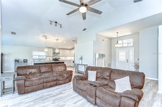 living area with light wood-type flooring, visible vents, and baseboards