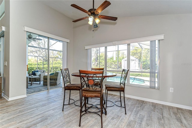 dining room with a sunroom, baseboards, ceiling fan, and light wood finished floors