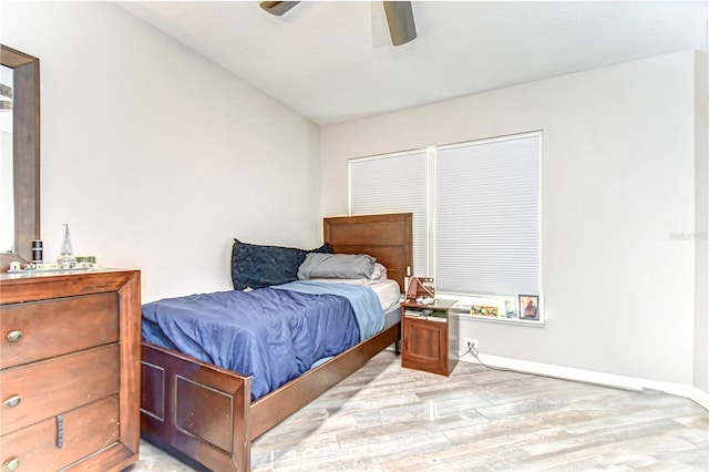 bedroom featuring a ceiling fan, lofted ceiling, baseboards, and light wood finished floors