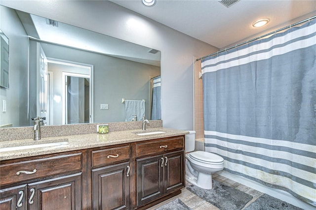 bathroom with toilet, double vanity, a sink, and a shower with shower curtain