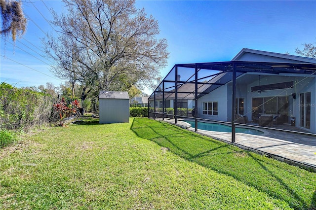 view of yard featuring an outbuilding, glass enclosure, a patio, a storage shed, and an outdoor pool