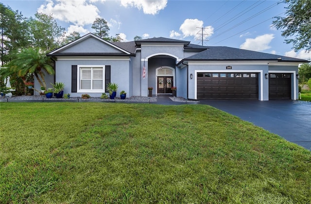 single story home featuring driveway, stucco siding, an attached garage, and a front yard