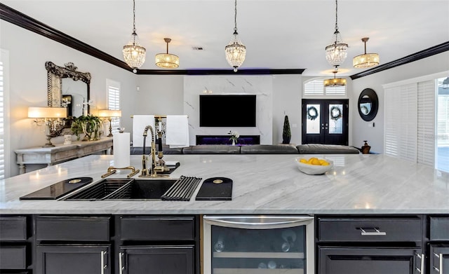 kitchen with ornamental molding, open floor plan, light stone counters, and french doors