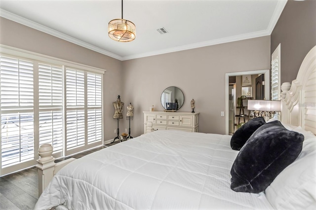 bedroom featuring wood finished floors, visible vents, and crown molding