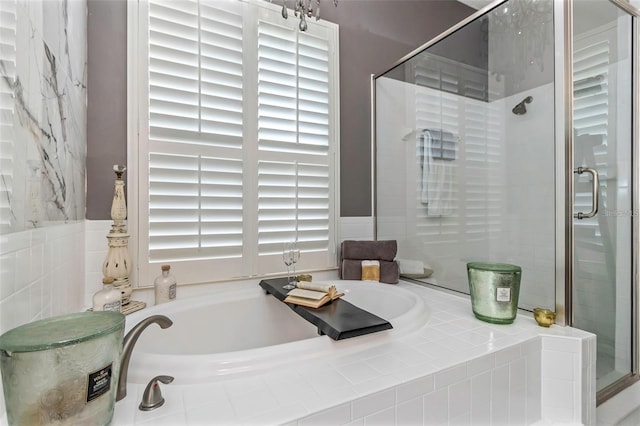 full bathroom featuring a stall shower and a bath