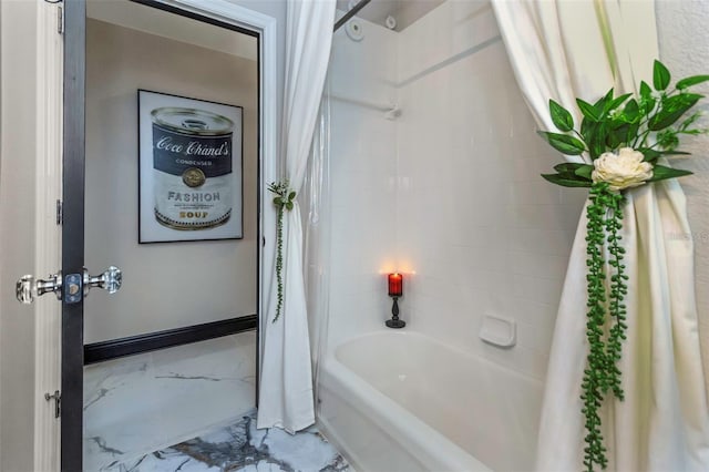 bathroom with marble finish floor, baseboards, and shower / tub combo with curtain