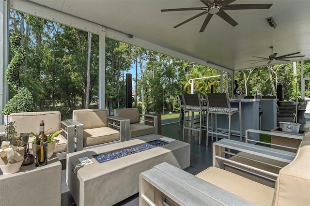 view of patio / terrace with ceiling fan and an outdoor living space with a fire pit