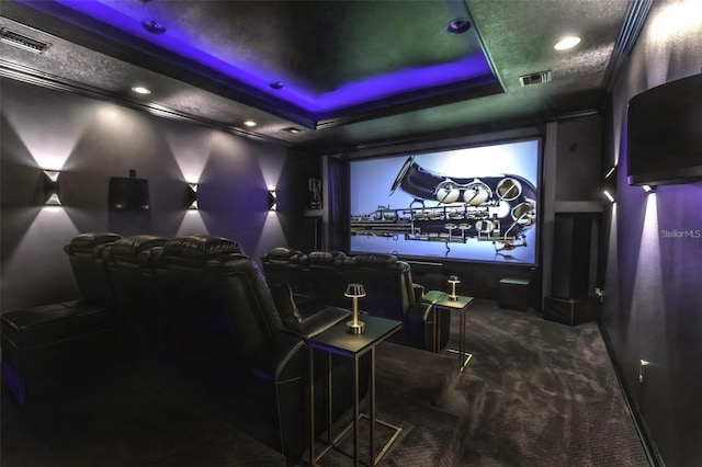 home theater room with dark colored carpet, visible vents, a tray ceiling, and recessed lighting