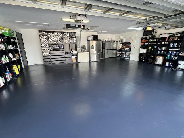 garage with stainless steel refrigerator with ice dispenser and a garage door opener