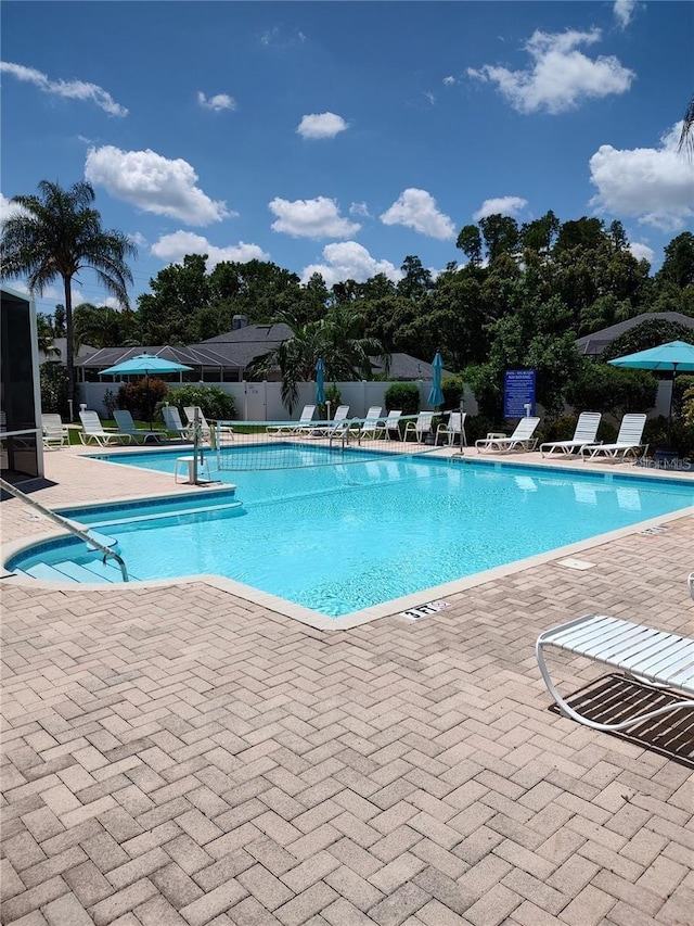 pool featuring fence and a patio