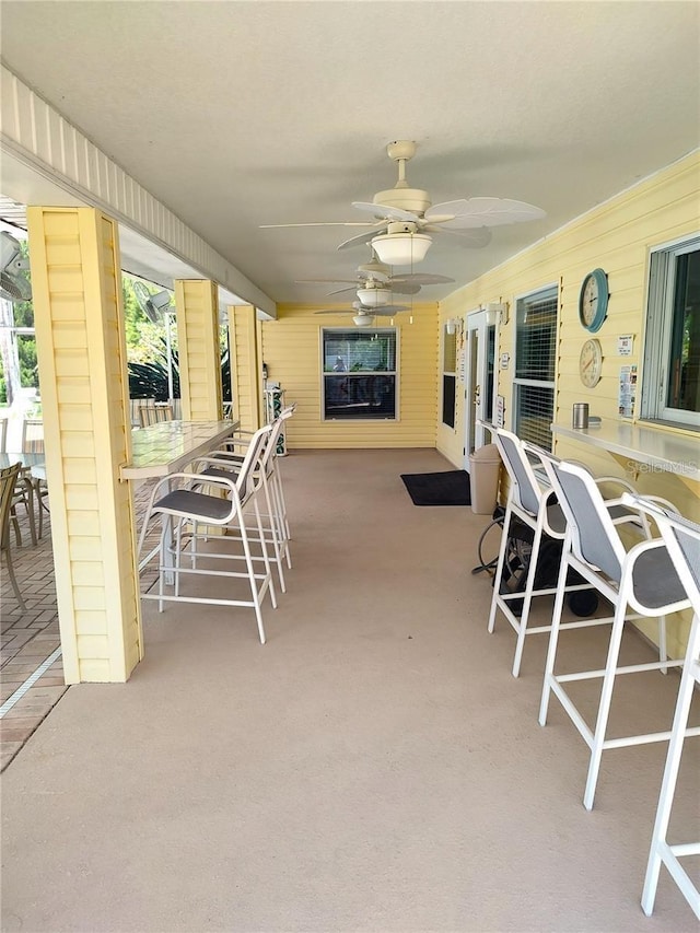 view of patio with outdoor dry bar and a ceiling fan