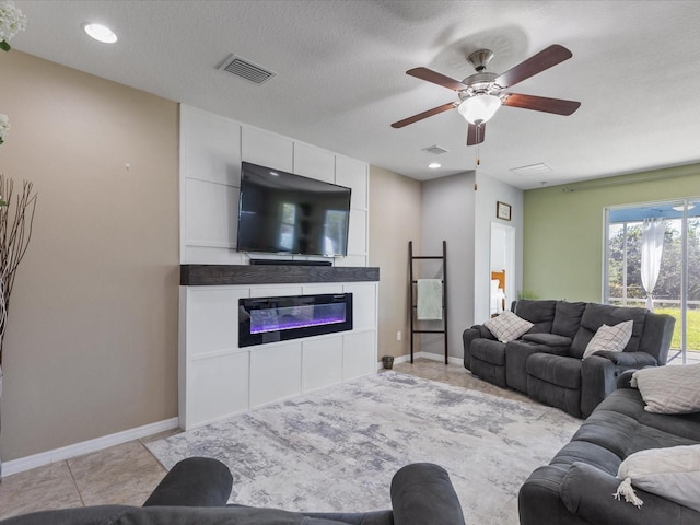 living area featuring a large fireplace, visible vents, baseboards, and light tile patterned floors