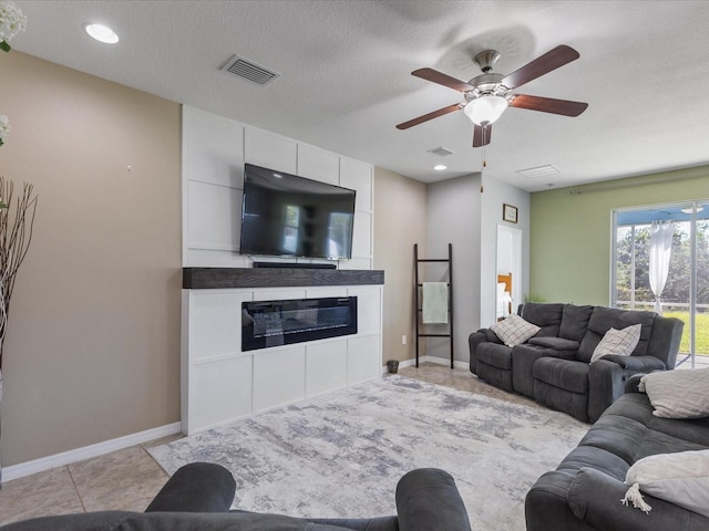 living room with a large fireplace, visible vents, baseboards, and light tile patterned flooring