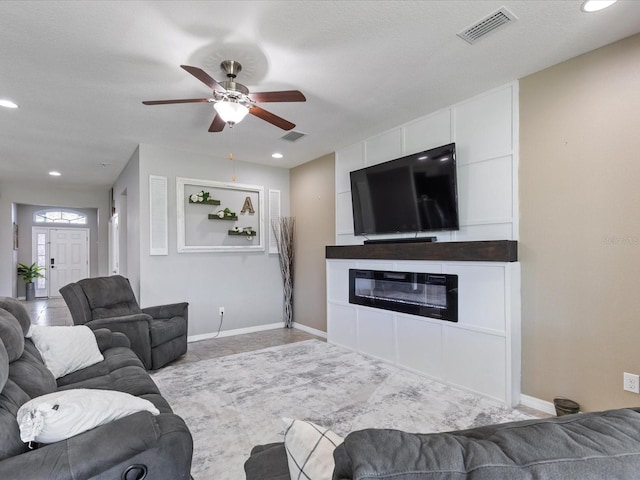 living room featuring a fireplace, visible vents, and baseboards