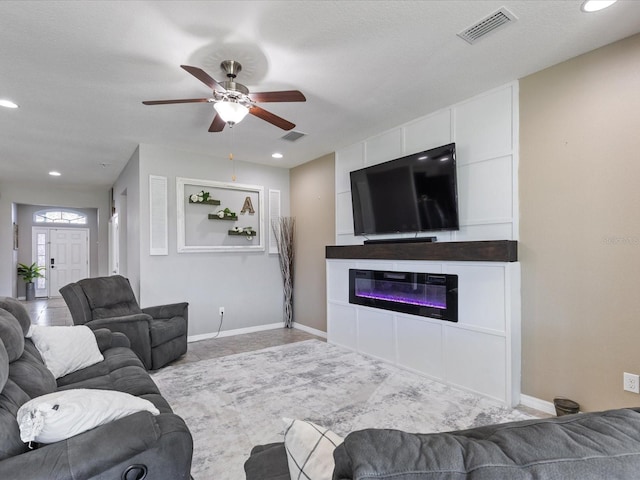 living room featuring baseboards, a fireplace, and visible vents