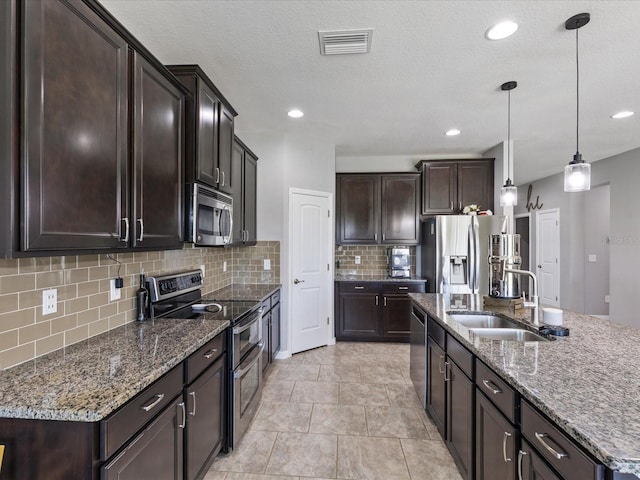 kitchen featuring dark brown cabinetry, visible vents, appliances with stainless steel finishes, and a sink