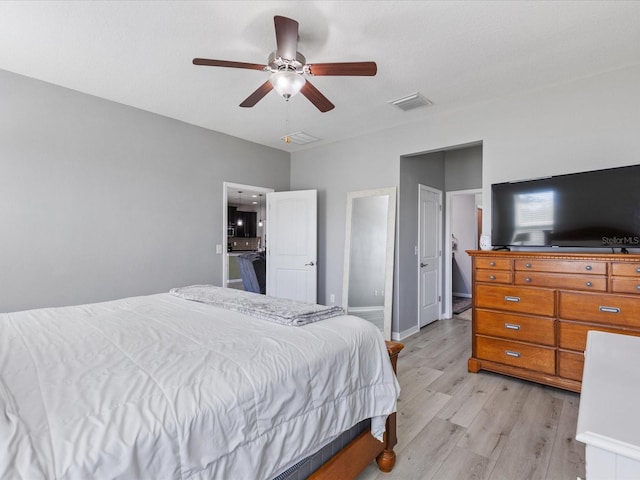 bedroom featuring visible vents, ceiling fan, light wood-style flooring, and baseboards