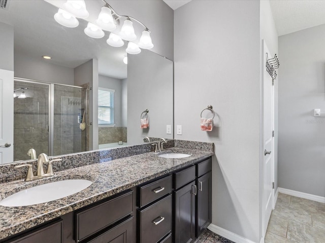 full bath featuring a stall shower, a sink, baseboards, and double vanity