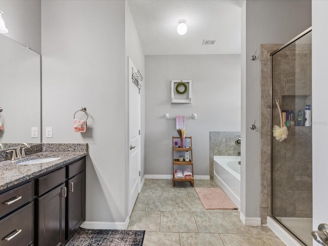 bathroom with a garden tub, visible vents, a stall shower, vanity, and baseboards