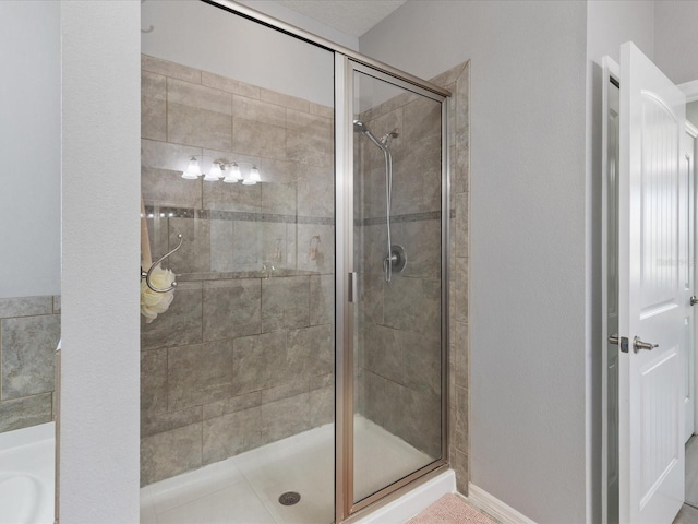 bathroom with a stall shower and baseboards