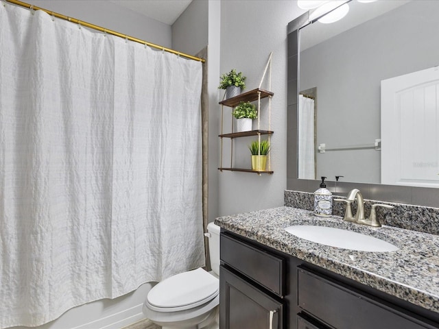 bathroom with toilet, shower / bath combo with shower curtain, and vanity