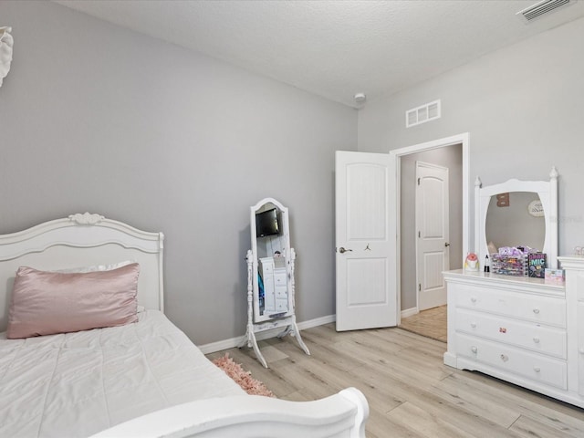 bedroom featuring light wood finished floors, baseboards, and visible vents