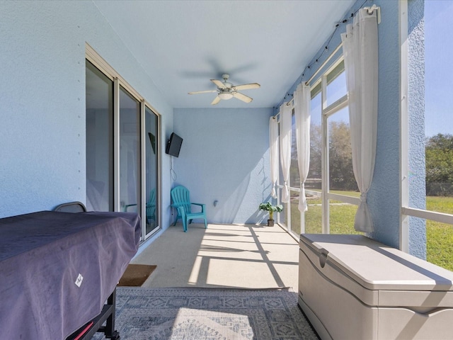 sunroom / solarium featuring a ceiling fan